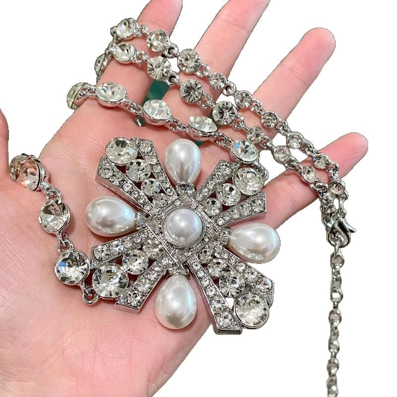 Collana lunga in argento con catena a croce e petali di perle, interamente tempestata di diamanti, cintura leggera e lussuosa con catena a diamanti rotondi.