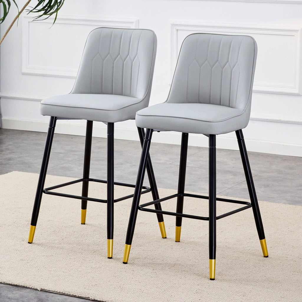Set di due sgabelli da bar, alti 100 cm, realizzati in similpelle PU grigio chiaro con struttura in metallo nero e comodo poggiapiedi. Disponibili in