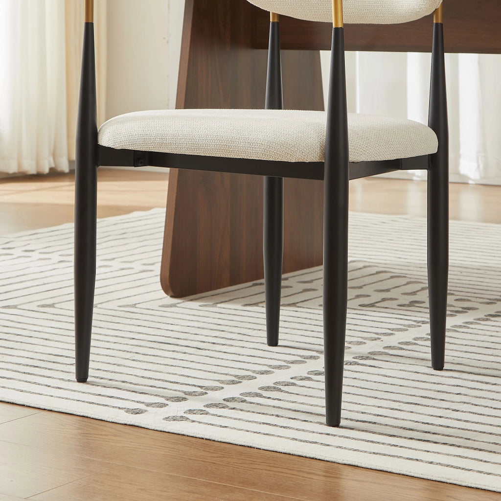 Chaise da pranzo in tessuto con struttura in metallo nero e dettagli oro, cuscini beige, braccioli
